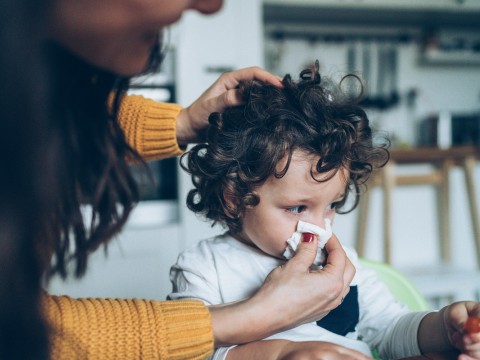 Mother wiping baby's nose