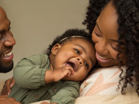 Mom and dad holding smiling baby